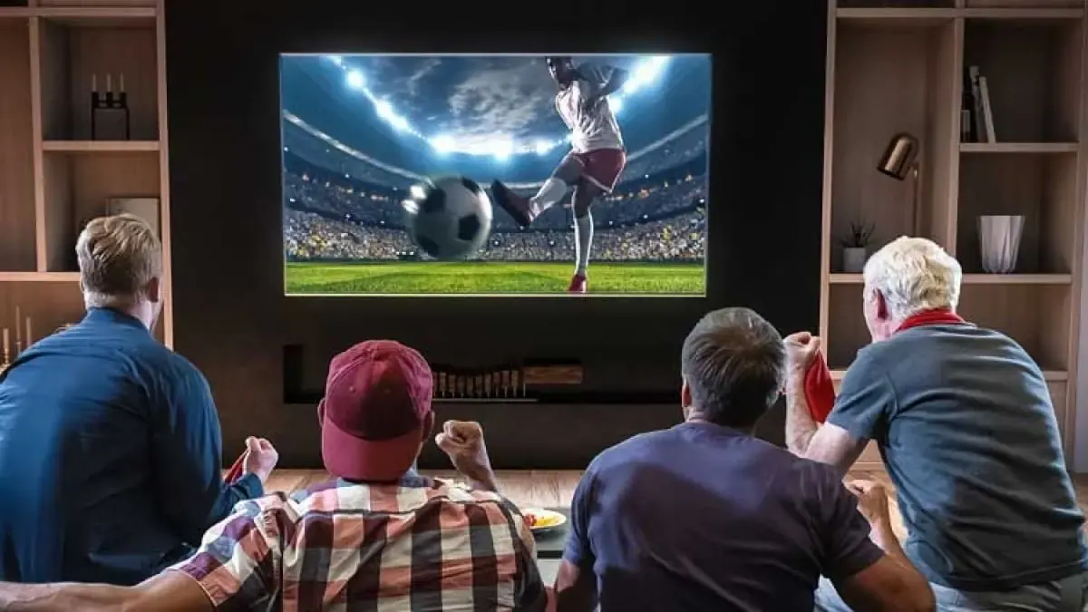 Supporters regardant un match de football à la télévision avec un abonnement IPTV premium en France